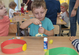 Chłopiec z grupy Stokrotki przykleja kropki