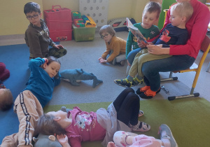 Dzieci słuchają opowiadania czytanego przez panią Sylwię