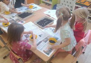 dziewczynki napełniają doniczki ziemią