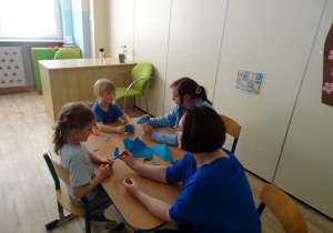 dzieci składają motylki z origami