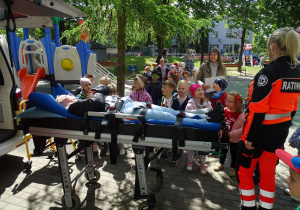 Pani Ania i Pani Iza pokazuja dzieciom jak wygląda ułożenie pacjenta na noszach