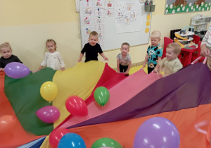 Wspólne zabawy z balonami i chustą animacyjną w grupie Rumianki.