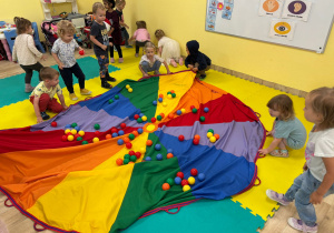 Wspólna zabawa z piłeczkami i chustą animacyjną w grupie Stokrotki.