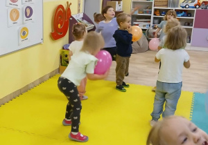 Dzieci z grupy Stokrotki tańczą z balonami do przedszkolnych piosenek.