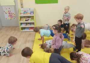 chłopiec pokazuje dzieciom ćwiczenie
