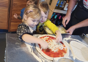 Dziewczynka ugniata ciasto na pizzę
