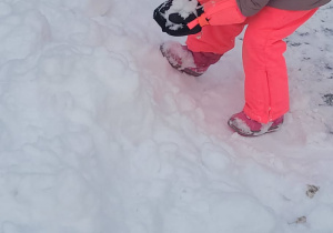 dziewczynka robi śniegową kulkę