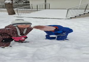 dziewczynki schylają się po śnieg