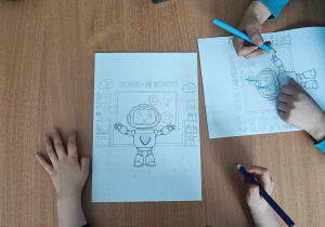 Dzieci kolorują obrazek z robotem