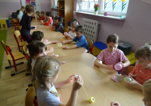 dzieci nawijają kordonek na baloniki