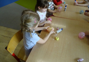 dziewczynki nawijają kordonek na baloniki