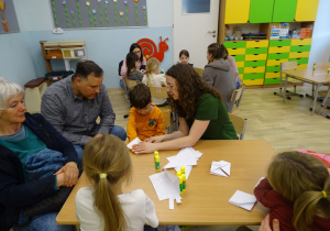 chłopiec składa koszyczek z origami