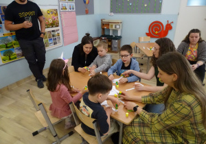 dzieci i rodzice składają koszyczki