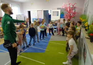 dzieci stoją i słuchają trenera