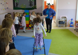 Dzieci przeskakują obunóż przez przeszkody