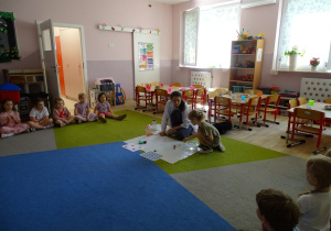 dziewczynka wkłada przedmiot do miski z wodą