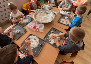 Dzieci lepią bałwany, rączki pracują.