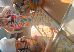 Dzieci układają ciasteczka na blasze