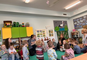 Dzieci siedzą w kole na dywanie