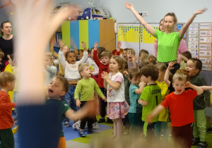 Wspólne zabawy przedszkolaków na dużej sali.