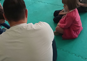 Dzieci słuchają książki czytanej przez rodzica
