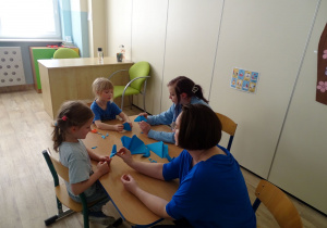 dzieci składają motylki z origami