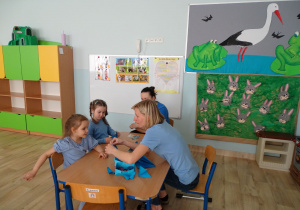 dzieci składają motylki z origami