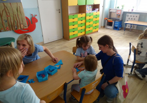 dzieci z rodzicami składają motylki origami