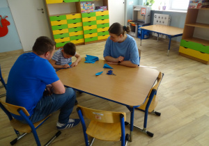 chłopiec składa motylka z origami
