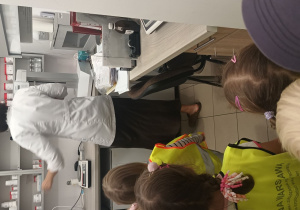 Dzieci patrzą na farmaceutkę, która przygotowuje lekarstwa