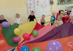 Wspólne zabawy z balonami i chustą animacyjną w grupie Rumianki.