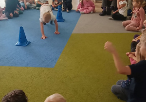 dziewczynka idzie między pachołkami na czworaka