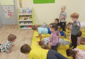 chłopiec pokazuje dzieciom ćwiczenie