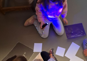 dziewczynki w świetle uv szukają ukrytych obrazków