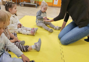 Dzieci dotykają skorupki kasztana.