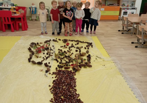 Dzieci prezentują drzewo z kasztanów.