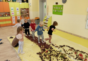 Dzieci chodzą po kasztanach.