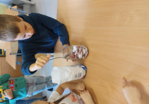 Chłopiec mieszka łyżką w słoiku.