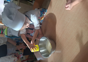 dziewczynka wsypuje mąkę do miski