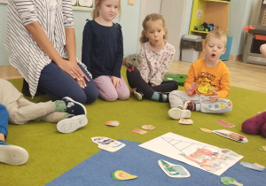 Dzieci siedzą na dywanie