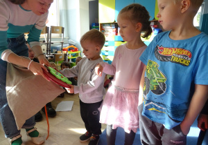 Dzieci losują z worka warzywo albo owoc