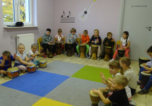 Dzieci grają na różnych bębnach