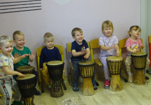 Wesołe dzieci grają na bębnach