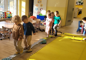Dzieci ćwiczą równowagę podczas zajęć w przedszkolu.