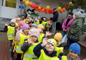 Dzieci ubrane w kamizelki odblaskowe wychodzą z przedszkola