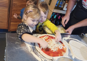 Dziewczynka ugniata ciasto na pizzę
