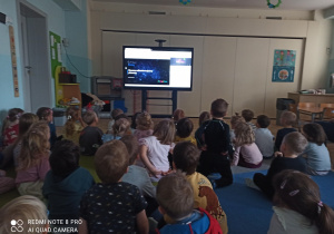 Dzieci siedzą na dywanie