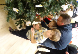 Wieszanie ozdobionych pierników na przedszkolną choinkę.