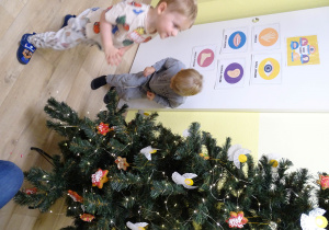 Wieszanie ozdobionych pierników na przedszkolną choinkę.