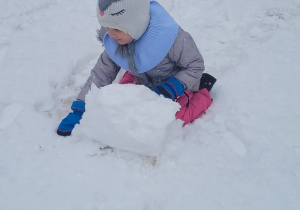 dziewczynka lepi śniegową kulę